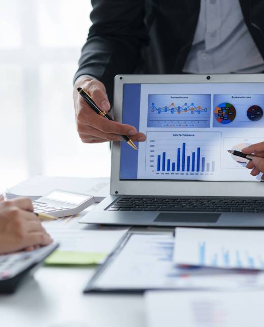 Business people point to graphs and charts on laptop to present at the meeting, analyze market data, balance sheet, net profit, to plan new sales strategies to increase productivity.
